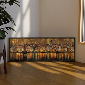 Può includere: Una stampa artistica panoramica incorniciata che raffigura lo skyline di una città di notte lungo un corso d'acqua. La scena presenta calde luci dorate, edifici dettagliati e un cielo vorticoso e strutturato, con riflessi che brillano sull'acqua.