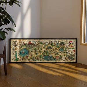 Op de afbeelding: Een ingelijste, geïllustreerde kaart met een zwarte rand. De kaart heeft een grillige, handgetekende stijl met verschillende bezienswaardigheden, waaronder een vulkaan, cactussen en een eend met een kerstmuts. Het kleurenpalet omvat groen, blauw en bruin.