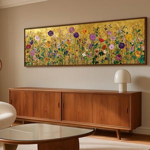 Puede incluir: Una pieza de arte mural rectangular que presenta un prado vibrante de flores coloridas sobre un fondo de pan de oro brillante, encerrada en un marco fino de color marr&oacute;n oscuro. La pintura muestra una variedad de flores en tonos morados, rojos y amarillos.