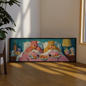 Peut inclure: Une impression d'art mural encadrée rectangulaire représentant un ours rose et un ours brun doré assis dans un lit avec une literie rose. Les deux ours mangent des parts de pizza au pepperoni. La scène inclut des tables de chevet avec des tasses.