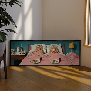 May include: A framed painting depicts two tigers in bed, each holding a slice of pizza. The artwork features a teal headboard, a pink blanket, and a nightstand with a lamp. The tigers are orange and black.