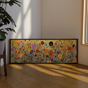 May include: A rectangular framed artwork depicting a colourful floral scene. The painting has a golden backdrop with flowers in orange, purple, red, and blue. The artwork is displayed on a wooden floor.