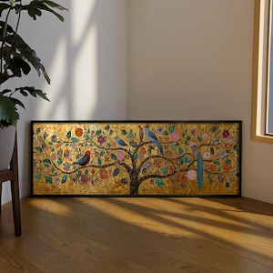 Puede incluir: Una pieza de arte mural rectangular en un marco negro con un fondo dorado y la silueta de un árbol oscuro. Las ramas del árbol están adornadas con flores coloridas y varios pájaros en tonos azules, rojos y marrones.