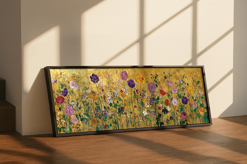 Puede incluir: Una pieza de arte mural rectangular en un marco negro que presenta una pintura vibrante de un prado florido. La obra muestra una densa colecci&oacute;n de flores coloridas en tonos morados, rojos, amarillos y rosas sobre un fondo dorado met&aacute;lico texturizado.