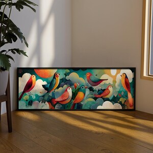 May include: A framed art print depicting a colourful illustration of birds amidst clouds and foliage. The birds are in shades of red, orange, blue, and green, set against a teal and white background. The artwork is enclosed in a black frame.