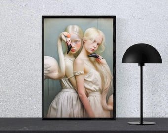 Op de afbeelding: Een ingelijste kunstdruk met twee figuren met lang blond haar, die elk een flamingo omarmen. De figuren dragen witte jurken en de flamingo's hebben zwarte snavels en roze accenten. Het kunstwerk wordt op een zwart oppervlak getoond.