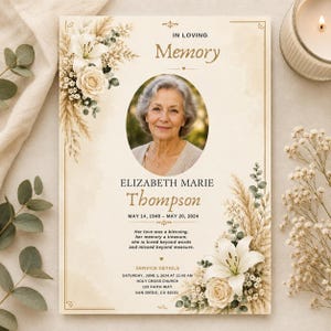 Op de afbeelding: Een uitvaartprogramma-sjabloon met een crèmekleurige achtergrond en gouden randen, versierd met witte lelies, rozen en pampasgras. Het bevat een centrale ovale foto van een ouder persoon, de tekst IN LOVING Memory, ELIZABETH MARIE Thompson, data en details over de dienst.