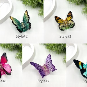 May include: A collection of nine butterfly-shaped decorative objects, each with a unique color scheme and design. The butterflies are labeled with the text "Style#" followed by a number from 1 to 9. The colors include green, blue, yellow, red, and purple.