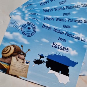 May include: A stack of postcards with a blue sky and cloud design. The text reads "Happy World Postcard Day From Estonia." A cartoon snail with glasses and a letter is on the left. The Estonian flag is also visible.