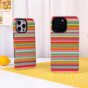 May include: Two rectangular phone cases featuring a vibrant, multi-colored horizontal striped pattern. The stripes consist of various shades of pink, orange, yellow, green, blue, and tan. Each case has a black camera cutout area at the top.