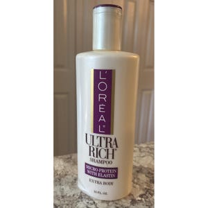 Puede incluir: Botella blanca de champú L'Oréal Ultra Rich con una etiqueta morada. La etiqueta incluye el nombre de la marca, el nombre del producto y los detalles del producto. La botella contiene 443 ml de champú.