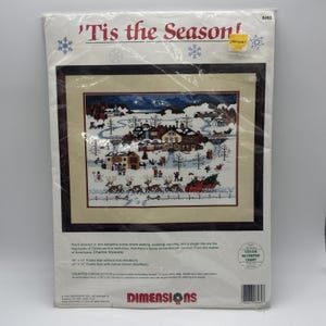 以下が含まれることがあります： Dimensionsのカウントクロスステッチキット「'Tis the Season!」。サンタクロースの乗ったそり、トナカイ、スケートをする人々が描かれた冬の村の風景。キットにはコットン糸、14カウントの白いアイーダ布、針、説明書が含まれています。
