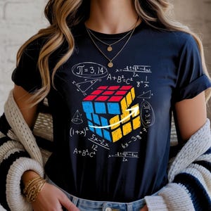 Pode incluir: Um conjunto de três canecas de cerâmica com acabamento fosco e salpicado. As canecas são em tons de creme, cinza claro e cinza escuro. Cada caneca tem um design simples e minimalista.