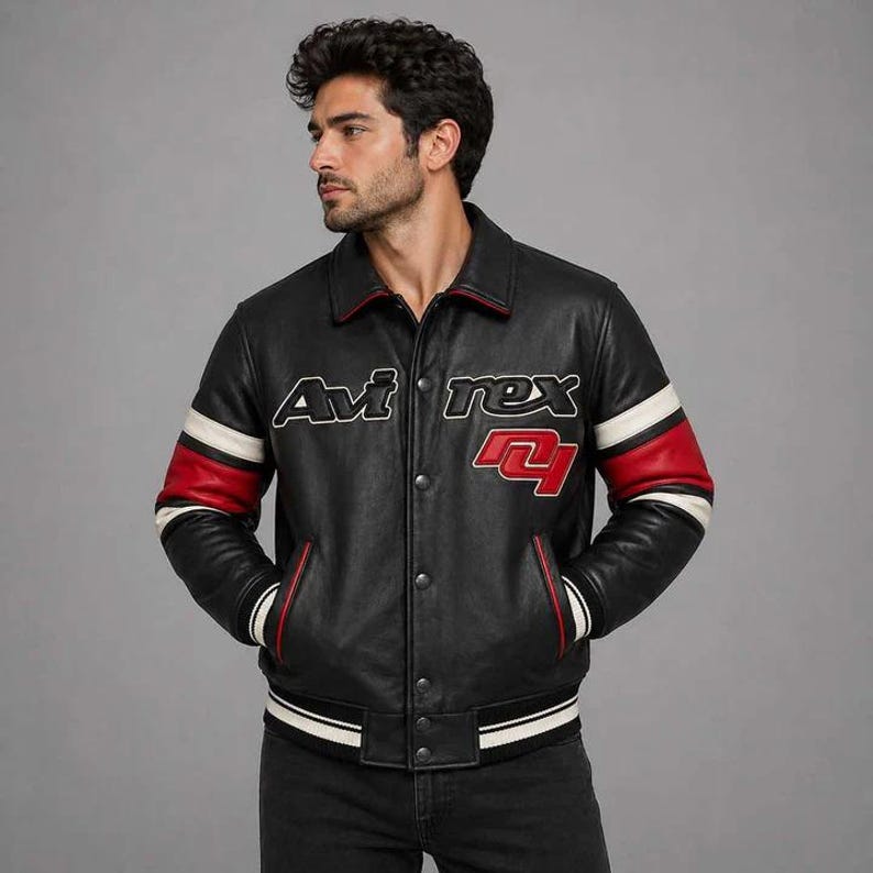 Pu&ograve; includere: Giacca in pelle nera con dettagli rossi e bianchi. La giacca presenta la scritta "Avi Rex" sul petto e un design rosso e bianco sulle maniche. Ha una chiusura con bottoni e un orlo a coste.