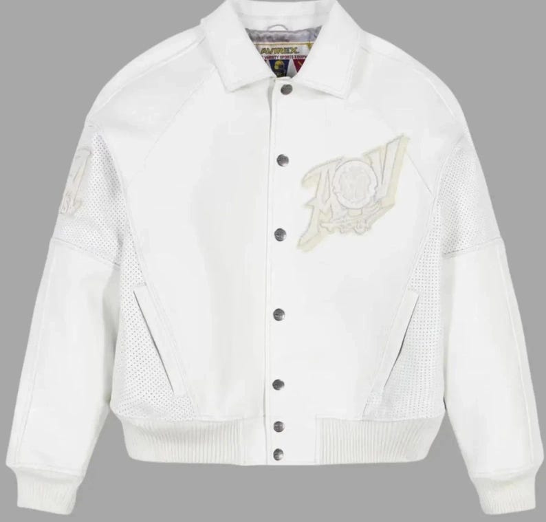 Puede incluir: Chaqueta de cuero blanca con cierre de botones y dobladillo y pu&ntilde;os acanalados. La chaqueta presenta un gran dise&ntilde;o bordado en la parte delantera y detalles perforados en las mangas. El cuello tiene la marca "AVIREX".