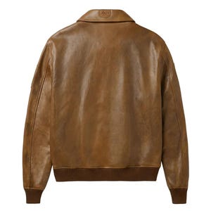 Pu&ograve; includere: Giacca in pelle marrone in stile bomber. Presenta collo, polsini e orlo a coste. Il retro della giacca &egrave; visibile, mostrando la consistenza e le variazioni di colore della pelle. Un piccolo stemma &egrave; visibile sul colletto.