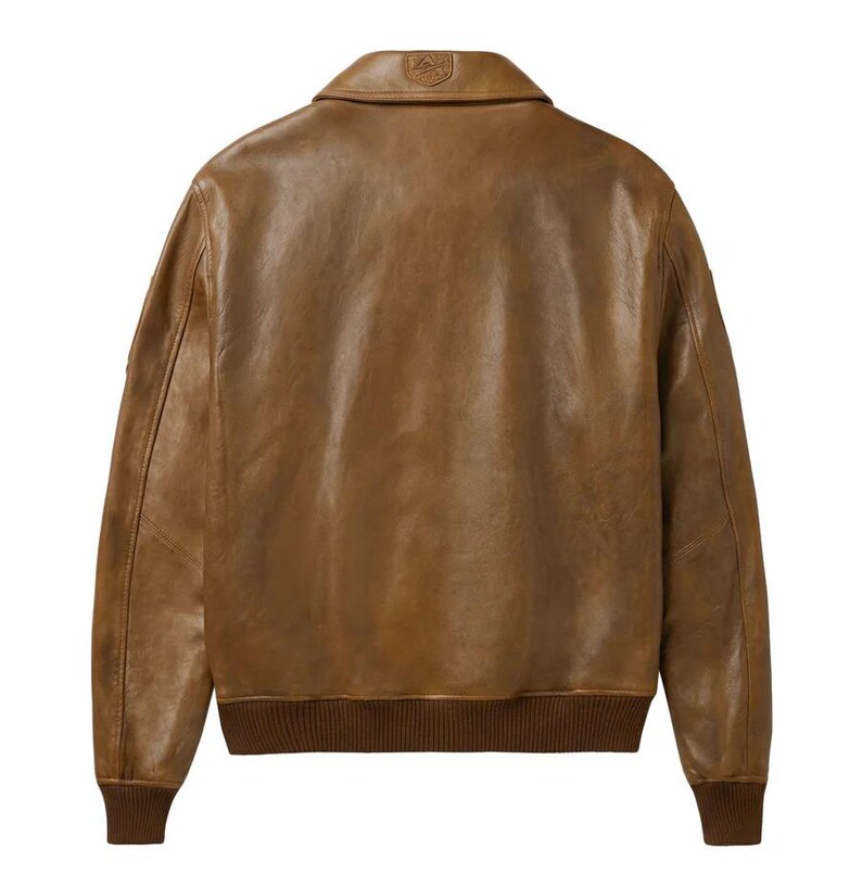 Pu&ograve; includere: Giacca in pelle marrone in stile bomber. Presenta collo, polsini e orlo a coste. Il retro della giacca &egrave; visibile, mostrando la consistenza e le variazioni di colore della pelle. Un piccolo stemma &egrave; visibile sul colletto.