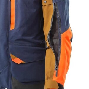 Puede incluir: Chaqueta de moto azul marino y naranja con el logo KTM. La chaqueta presenta detalles en naranja en las mangas y los bolsillos, con una abertura con cremallera en la manga. La chaqueta tiene cuello y pu&ntilde;os negros.