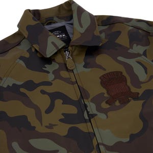 May include: Camouflage pattern jacket with a zipper closure and a collared neckline. The jacket features a brown patch on the chest. The color palette includes shades of green, brown, and black.