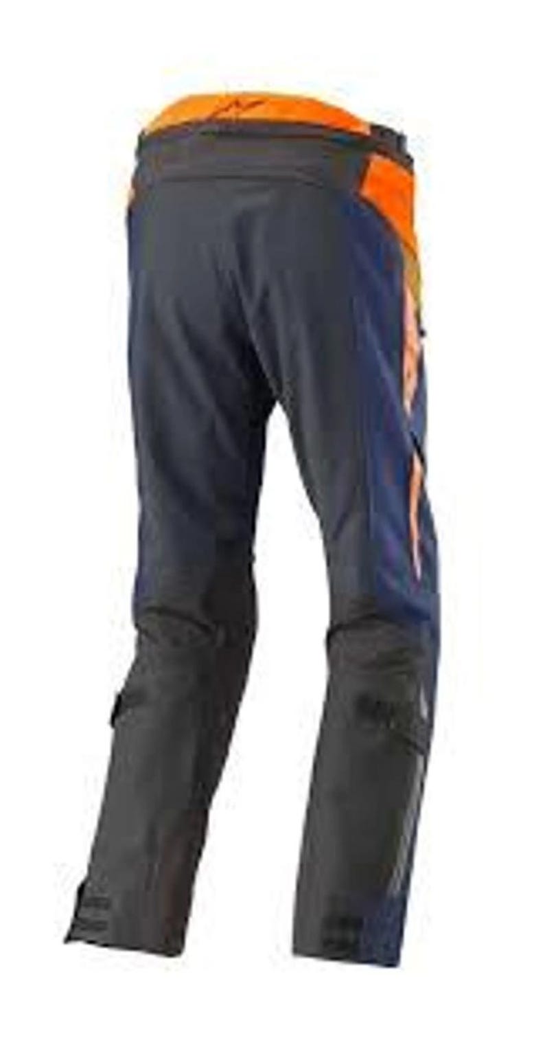 Puede incluir: Pantalones de moto azul marino oscuro y naranja. Los pantalones tienen detalles en naranja en la parte superior de la espalda y los laterales, con paneles negros en la parte inferior de las piernas. Dise&ntilde;ados para protecci&oacute;n y durabilidad.