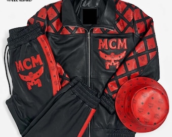 Könnte beinhalten: Ein Set aus einer Lederjacke, einer passenden Jogginghose und einem Fischerhut in Schwarz und Rot. Die Jacke hat einen schwarzen Kragen, einen durchgehenden Reißverschluss und ein rotes Rautenmuster an den Schultern. Das MCM-Logo ist in Rot aufgestickt.