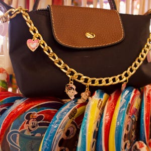 May include: A white ceramic mug with a black handle and the text "But First, Coffee" in a black, handwritten-style font. The mug is on a white surface.