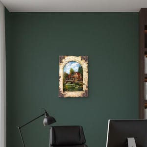 May include: A framed landscape painting of a rural scene with a house, bridge, and water. The painting is displayed on a dark green wall in an office setting, with a desk, chair, and bookshelf visible.