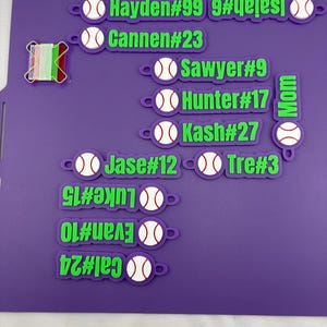 Pu&ograve; includere: Una collezione di etichette personalizzate per borse a tema baseball, viola e verdi, con icone di baseball bianche e nomi con numeri di maglia: Hayden#99, Isaiah#6, Cannen#23, Sawyer#9, Hunter#17, Kash#27, Jase#12, Tre#3, Luke#15, Evan#10, Cal#24 e Mom.