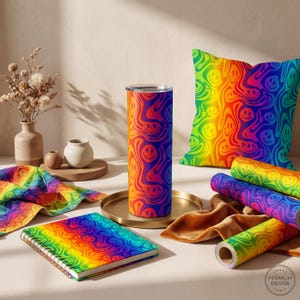 Pode incluir: Uma coleção de itens coloridos com arco-íris com um padrão de carinhas sorridentes. Os itens incluem um copo, uma almofada, um caderno, tecido e rolos de papel. O esquema de cores vai do vermelho ao laranja, amarelo, verde e azul.