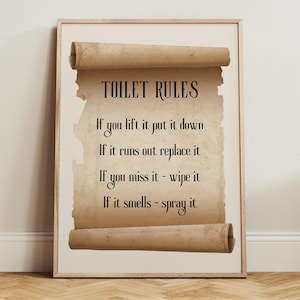 May include: Framed print with the text "TOILET RULES" on a parchment-style background. The rules are: "If you lift it put it down", "If it runs out replace it", "If you miss it - wipe it", and "If it smells - spray it".