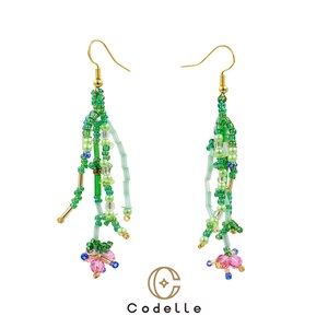 May include: A pair of beaded dangle earrings with gold-colored hooks. The earrings feature a cascade of green, light green, and blue beads, with pink and blue floral accents at the bottom. The brand name "Codelle" is at the bottom.