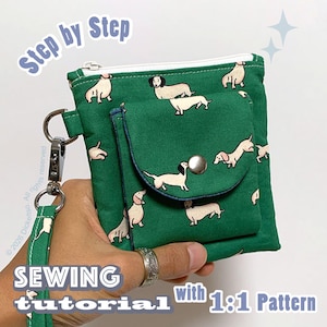 Könnte beinhalten: Eine grüne Stofftasche mit einem wiederkehrenden Muster aus beigen und schwarzen Dackeln. Die Tasche hat einen weißen Reißverschluss, eine Vordertasche mit silbernem Druckknopf und eine passende Handschlaufe mit silbernem Karabinerhaken. Der Text lautet Step by Step SEWING tutorial with 1:1 Pattern.