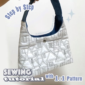 May include: A white fabric handbag featuring a black stitched outline pattern of houses with triangular roofs and windows. The bag has a dark blue strap and a single silver metal snap closure. Text on the image reads Step by Step SEWING tutorial with 1:1 Pattern.