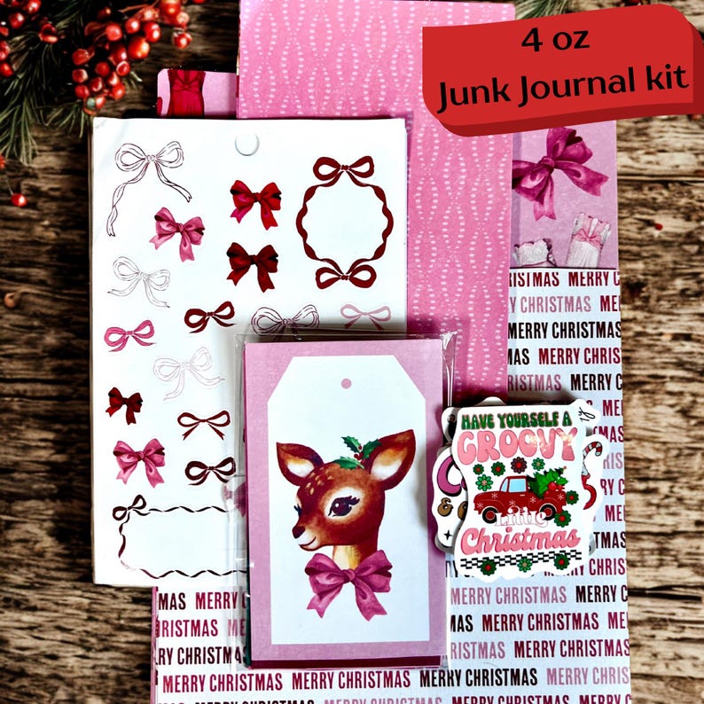 May include: A Christmas junk journal kit featuring pink and white designs. The kit contains bow stickers, a tag with a deer illustration, and patterned paper. The text "4 oz Junk Journal kit" is displayed on the packaging.