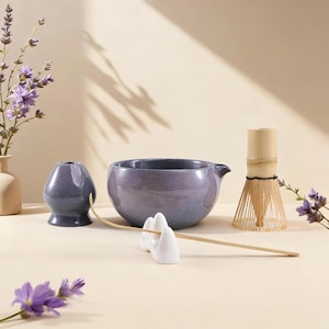 Könnte beinhalten: Set aus drei Keramikbechern mit gesprenkelter, matter Oberfläche. Die Becher sind in Creme-, Hellgrau- und Dunkelgrautönen gehalten. Jeder Becher hat ein schlichtes, modernes Design und einen abgerundeten Henkel. Höhe ca. 10 cm.