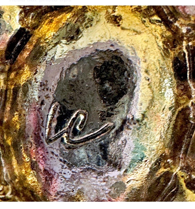 Peut inclure: Gros plan sur une surface textur&eacute;e multicolore avec des teintes dor&eacute;es, marron et violettes. Un monogramme stylis&eacute; "kc" de couleur argent&eacute;e est centr&eacute;, ajoutant une touche d'&eacute;l&eacute;gance au design abstrait.