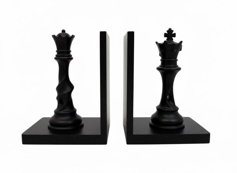 May include: Black chess piece bookends featuring a queen and a king. The bookends are made of a dark, textured material and are designed to hold books upright. The chess pieces are detailed and add a touch of elegance to any bookshelf.