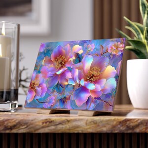 Op de afbeelding: Een rechthoekige kunstdruk op een houten standaard met een levendige bloemenillustratie. Het ontwerp toont grote, gelaagde pioenroosachtige bloemen in iriserende tinten roze, paars, blauw en goud tegen een zachte, vervaagde aquarelachtergrond.