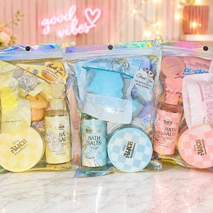 Puede incluir: Tres bolsas de plástico iridiscente que contienen productos de baño con temática de Disney Alicia en el país de las maravillas. Cada set incluye un frasco de sales de baño, un recipiente redondo y una bomba de baño en tonos amarillo, azul y rosa.