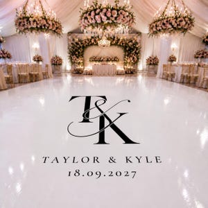 May include: A glossy white dance floor decal featuring a large black monogram of the letters T and K intertwined with an ampersand. Below the monogram, the text reads TAYLOR & KYLE followed by the date 18.09.2027 in a clean black serif font.