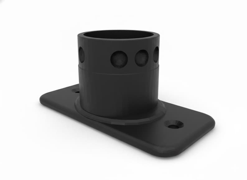 May include: A black metal pipe flange with a cylindrical socket and a rectangular base. The socket has three circular openings. The base has two holes for mounting. The object is set against a white background.