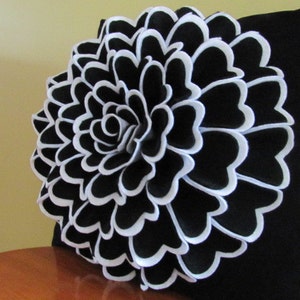 Peut inclure: Un coussin noir et blanc avec un grand motif de fleur noire bordée de blanc.