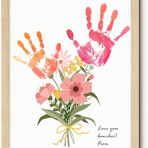 May include: Framed print with two handprints above a floral bouquet. The handprints are in orange and pink hues. The bouquet features pink and yellow flowers, tied with a yellow ribbon. Text reads "Love you bunches! From".