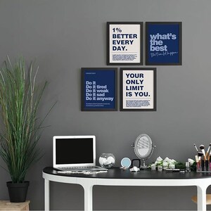 May include: Four framed motivational posters with black frames and white or navy blue backgrounds. The posters display text such as "1% Better Every Day" and "Your Only Limit Is You." A laptop, mirror, and makeup brushes sit on a black and white desk.