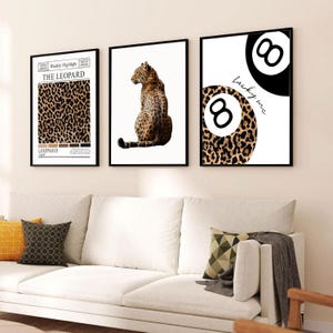 May include: A set of three framed wall art prints. The left print features a leopard print pattern with the text "Weekly Highlight THE LEOPARD". The center print shows a leopard sitting. The right print displays two eight balls, one with a leopard print.