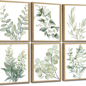 May include: Six framed botanical prints featuring watercolor illustrations of various green leaves and flowers. Each print is set against a white background and framed in a light brown wooden frame. The artwork showcases a natural, serene aesthetic.