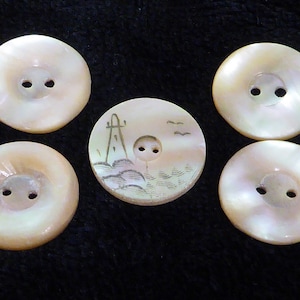May include: Five pearl buttons with two holes each. One button has a delicate etched design of a landscape with birds and a tower.