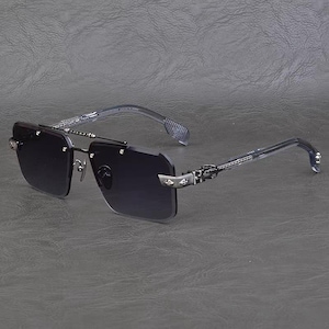 Puede incluir: Gafas de sol sin montura con lentes oscuras y detalles met&aacute;licos plateados. Las patillas y el puente presentan detalles intrincados. Las gafas de sol tienen forma rectangular y un dise&ntilde;o moderno.