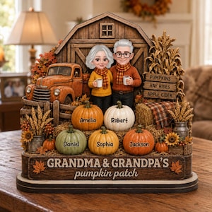 May include: A decorative tabletop display featuring a barn backdrop, a vintage truck, and two figures holding mugs. Five pumpkins are arranged in front, each labeled with names: Amelia, Robert, Daniel, Sophia, and Jackson. The base reads GRANDMA & GRANDPA'S pumpkin patch.