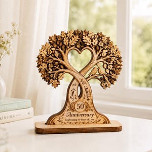 May include: A wooden anniversary tree sculpture with a heart-shaped cutout in the center. The tree features intertwined branches, a bird, and the words "Emily" and "Michael". The base reads "50 Anniversary Celebrating 50 Years of Love."